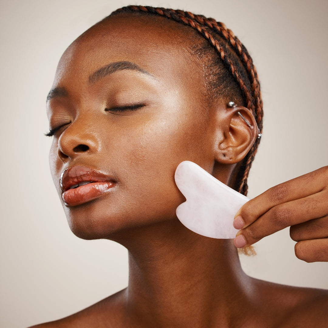 femme se massant le visage avec un gua sha