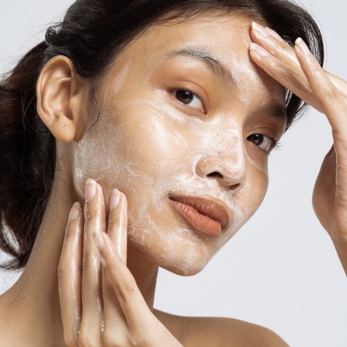 Femme hydratant son visage le soir