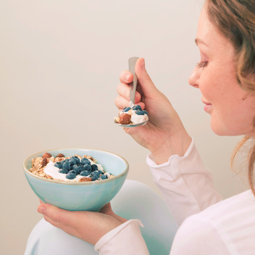 femme qui mange des myrtilles antioxydantes pour la peau